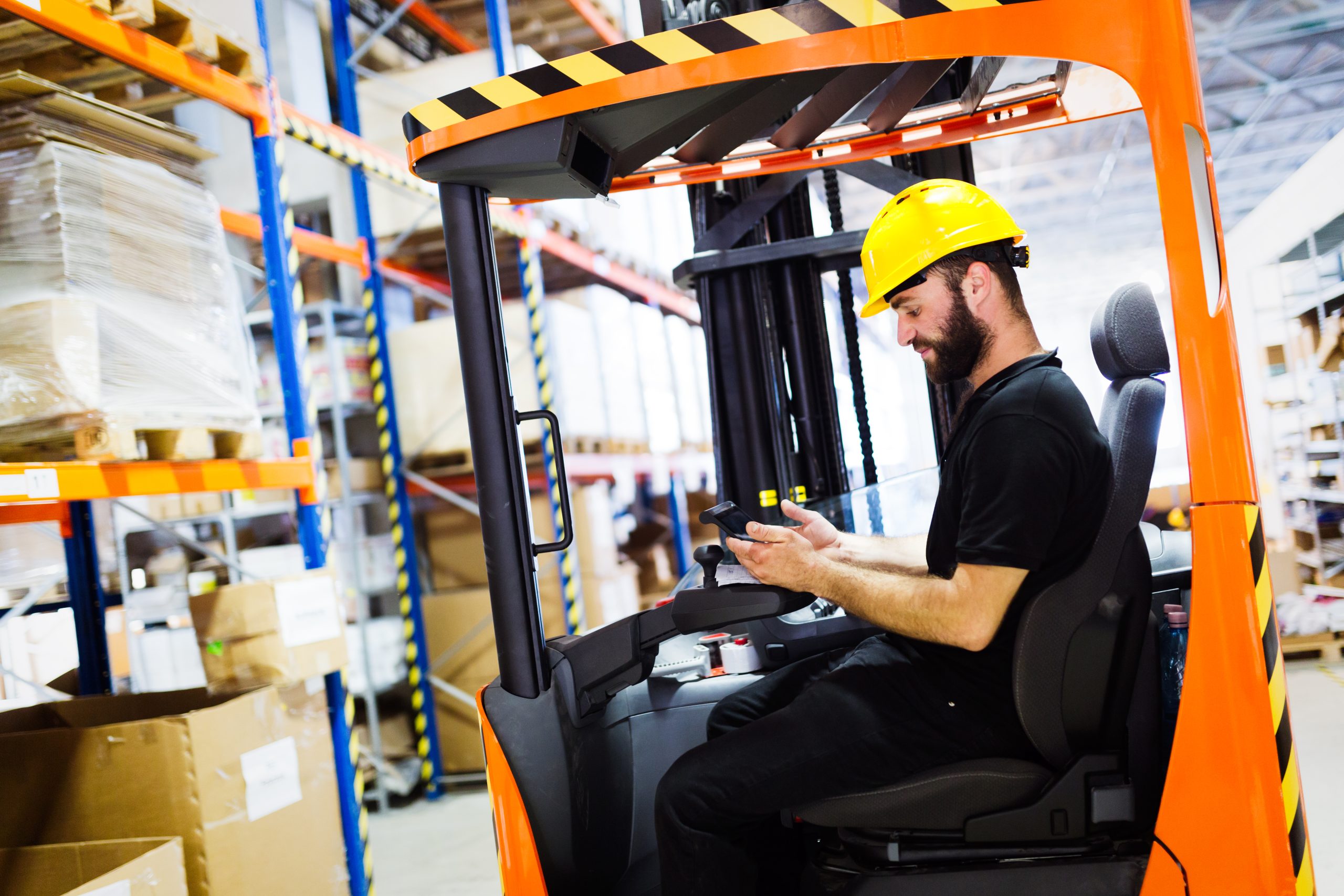 Warehouse worker doing logistics work with forklift loader